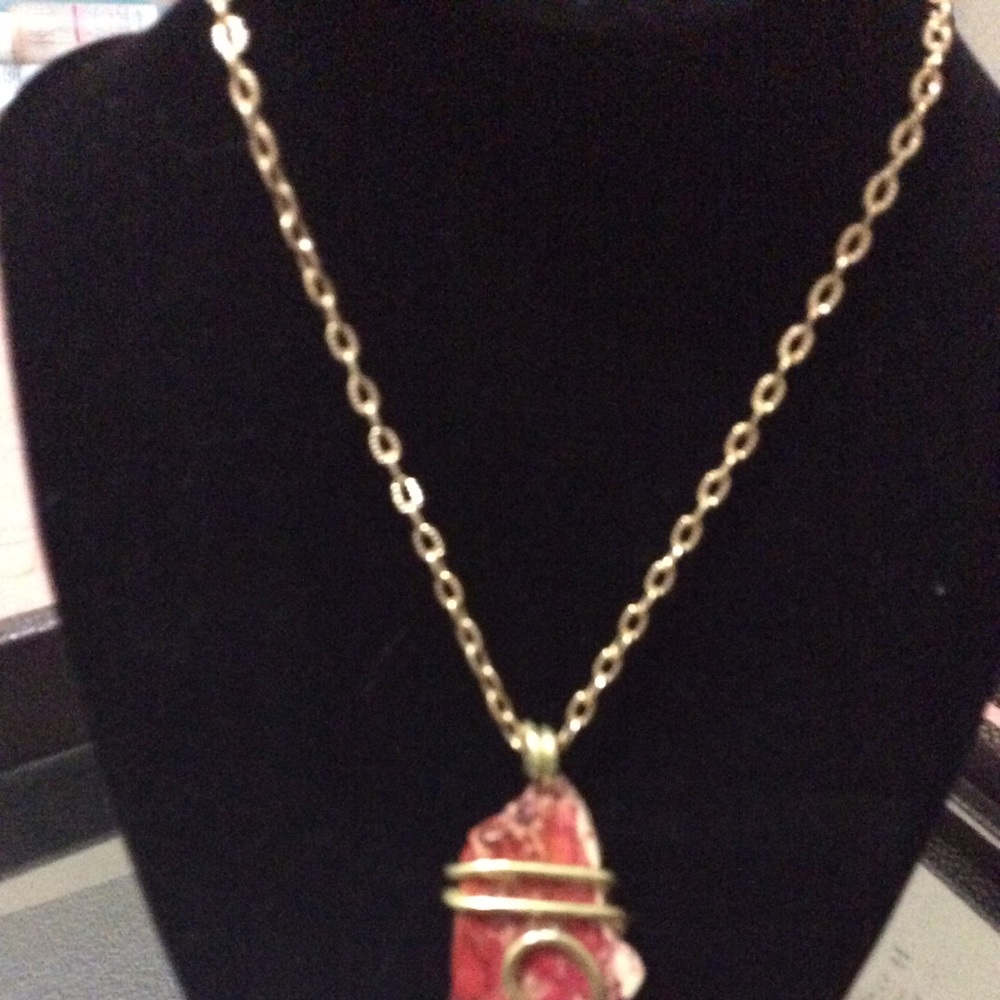 Brick colored stone wrapped in gold.